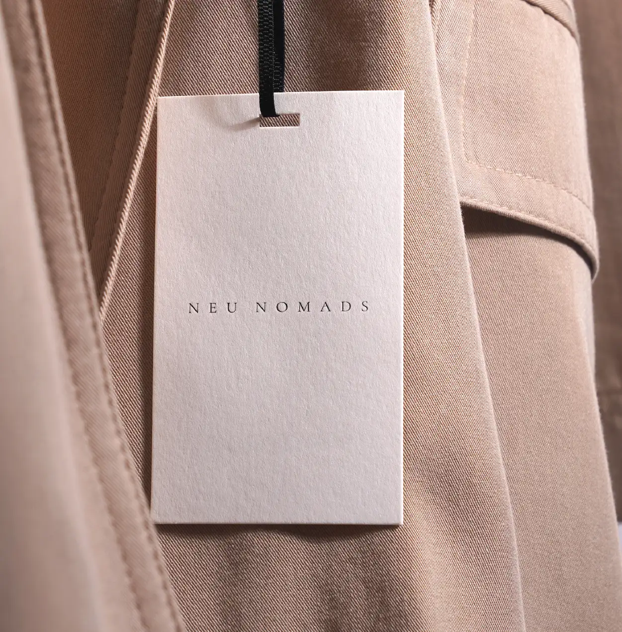 Neu Nomads branded swing tag on a clay-toned garment