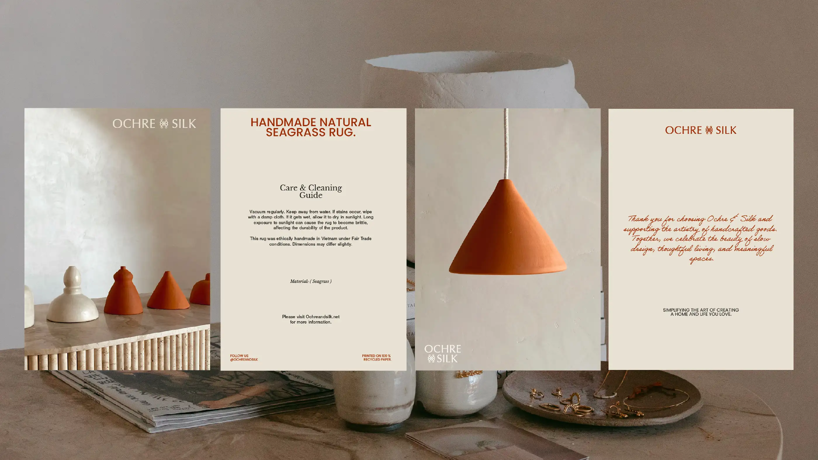 Ochre and Silk printed collateral — product care cards and a pendant light styled on a timber surface