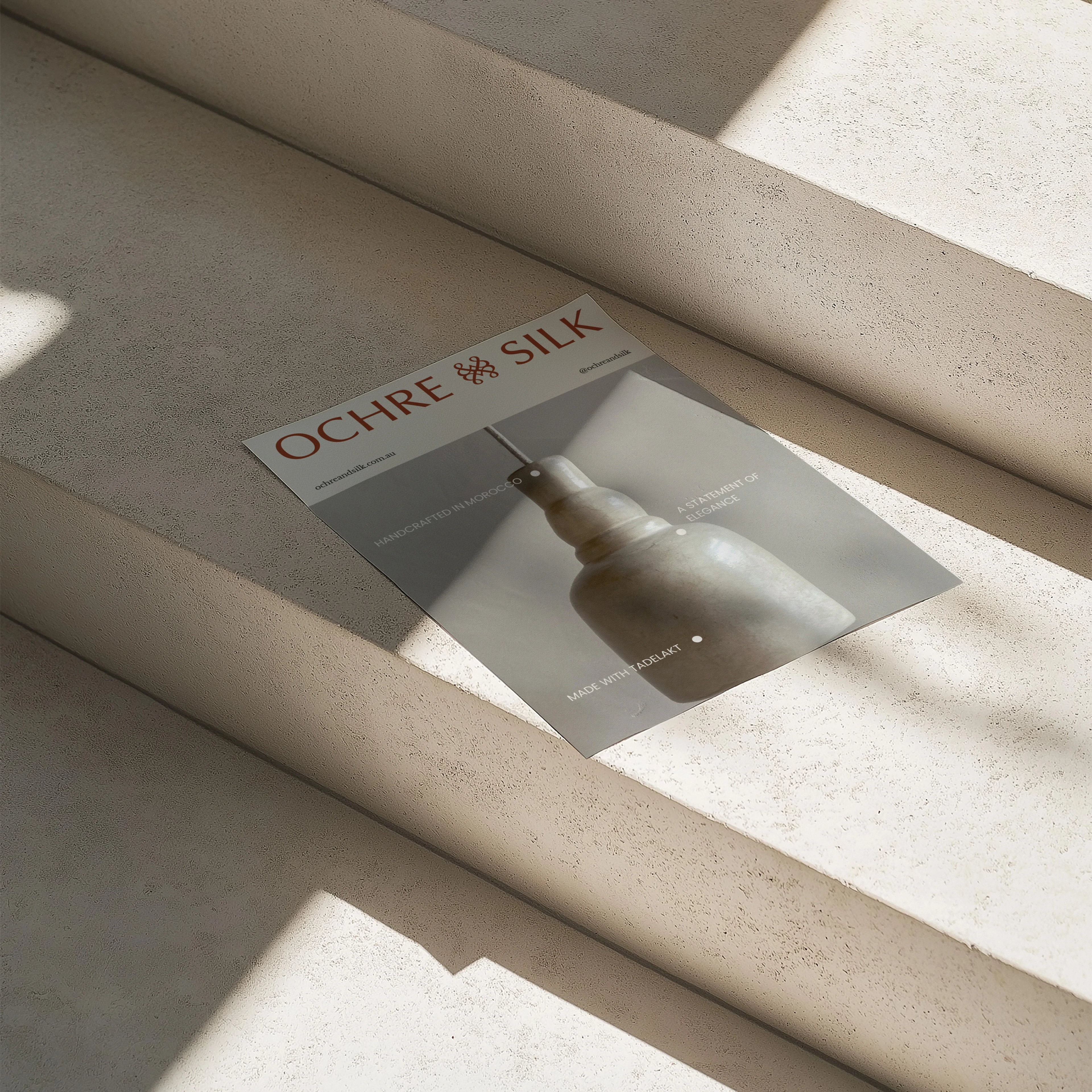 Ochre and Silk printed insert card photographed in raking light on ribbed stone