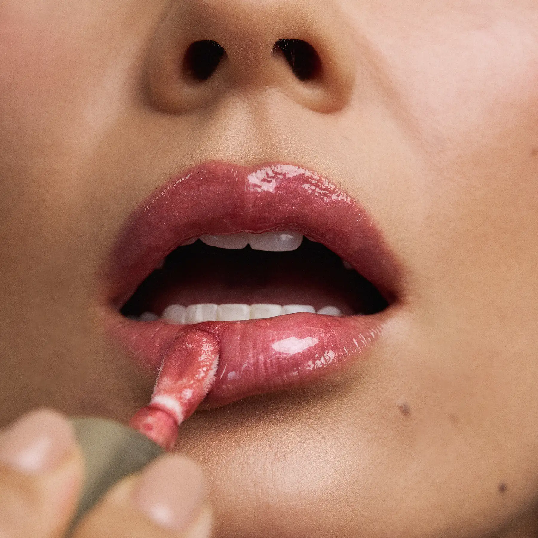 Beauty close-up of a model applying Napoleon Perdis lip gloss