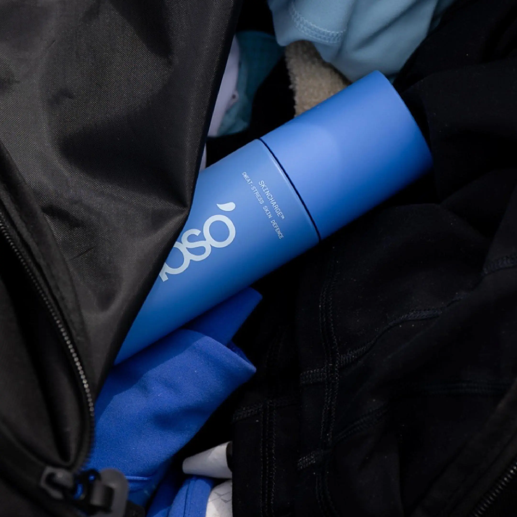 Blue Noso recovery spray bottle tucked into a sports bag
