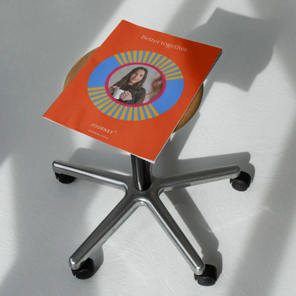 Journey HS brochure in orange resting on an office chair, reading 'Better together'