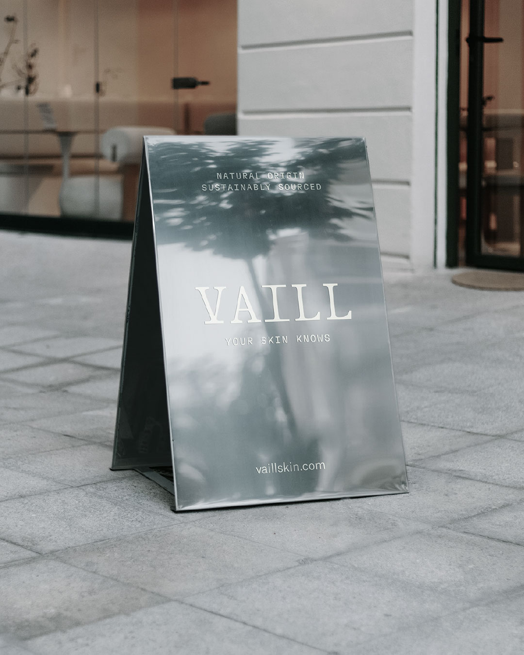 Vaill A-frame sign in a mirrored finish on a paved street